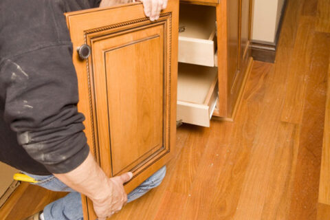 A worker fitting Cabinet Refacing