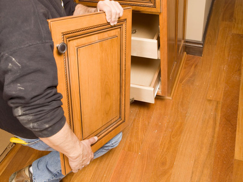 A worker fitting Cabinet Refacing