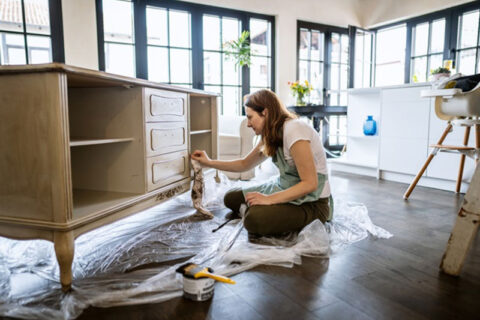 A women cleaning a wooden cabinet