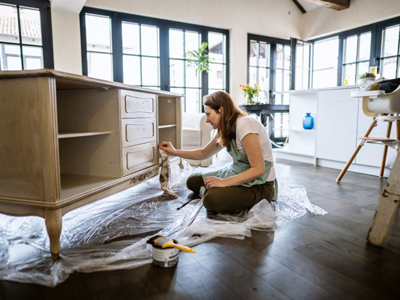 A women cleaning a wooden cabinet